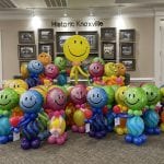 colorful balloon buddies make senior citizen smile by Above the Rest Balloons